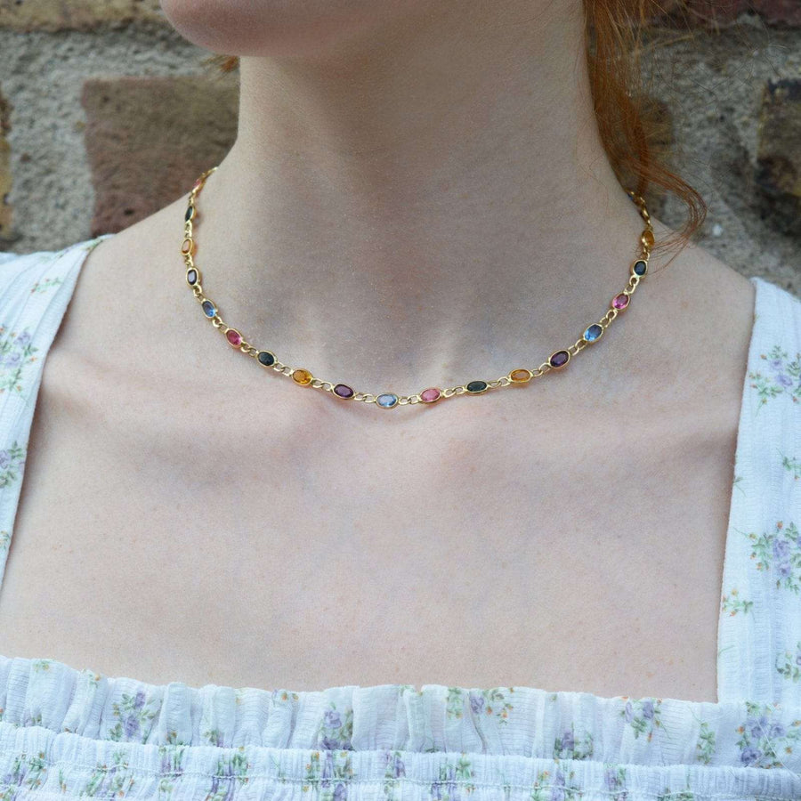 Vintage 18ct gold colorful multi-stone paste chain necklace showcased on a model's neck.