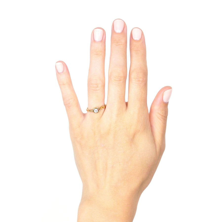 Vintage 18ct gold solitaire ring featuring a bezel-set diamond on a hand with neutral nail polish.