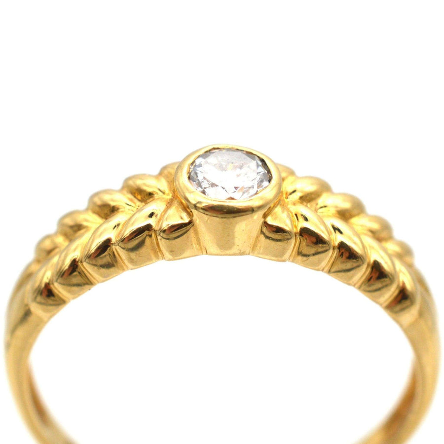 Vintage 18ct gold diamond solitaire ring with laurel wreath shoulders and 0.20 carat center stone.