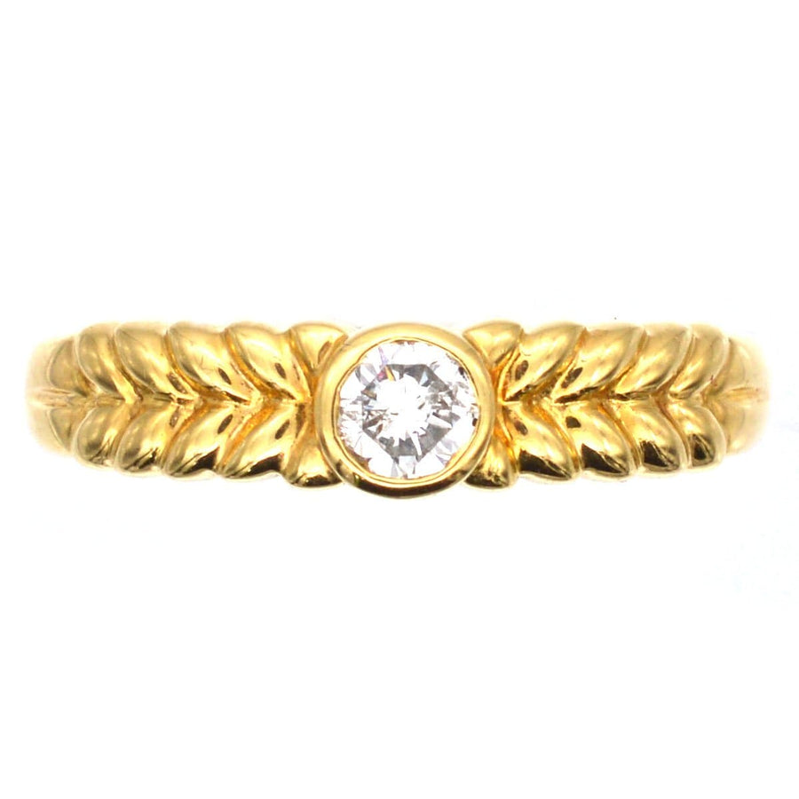 Vintage 18ct gold diamond solitaire ring with laurel wreath shoulders, featuring a central 0.20 carat bright white diamond.