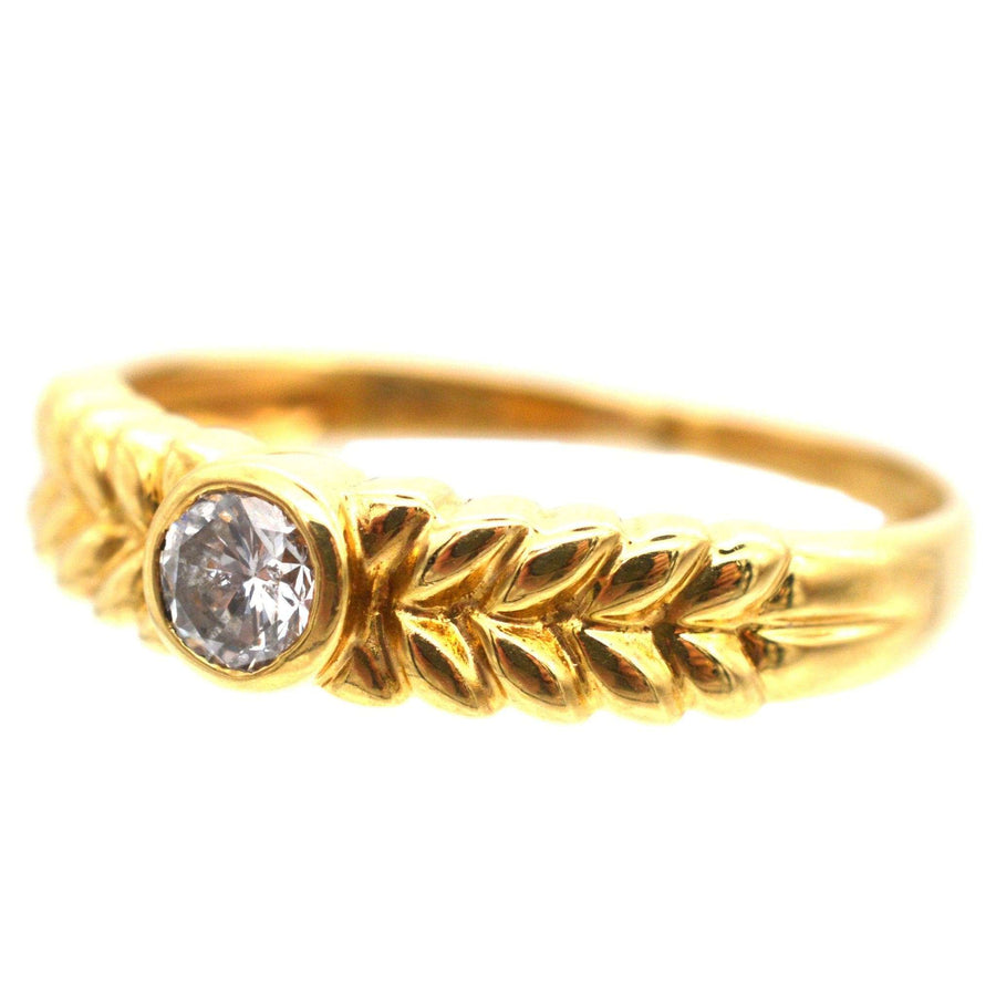 Vintage 18ct gold diamond solitaire ring with laurel wreath design shoulders.