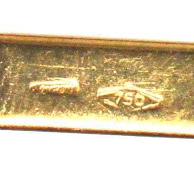 Close-up of gold hallmark showing 750 stamp on vintage cufflinks.
