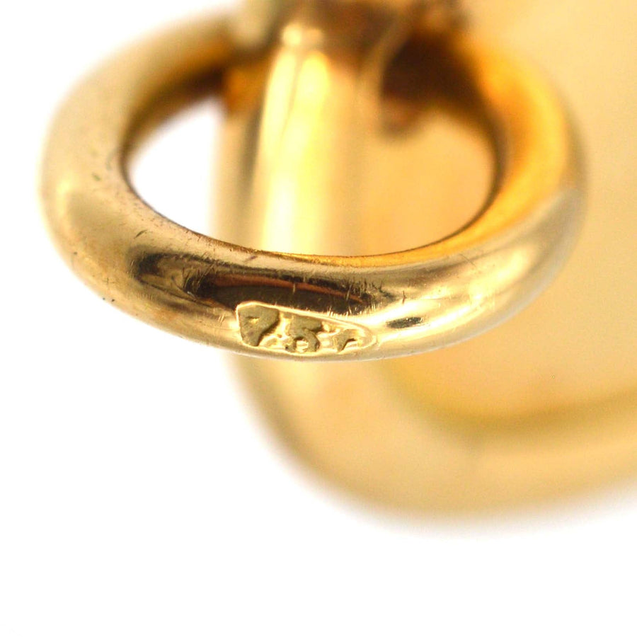Close-up of vintage 18ct gold oval pendant tag showing detailed clasp and hallmark.