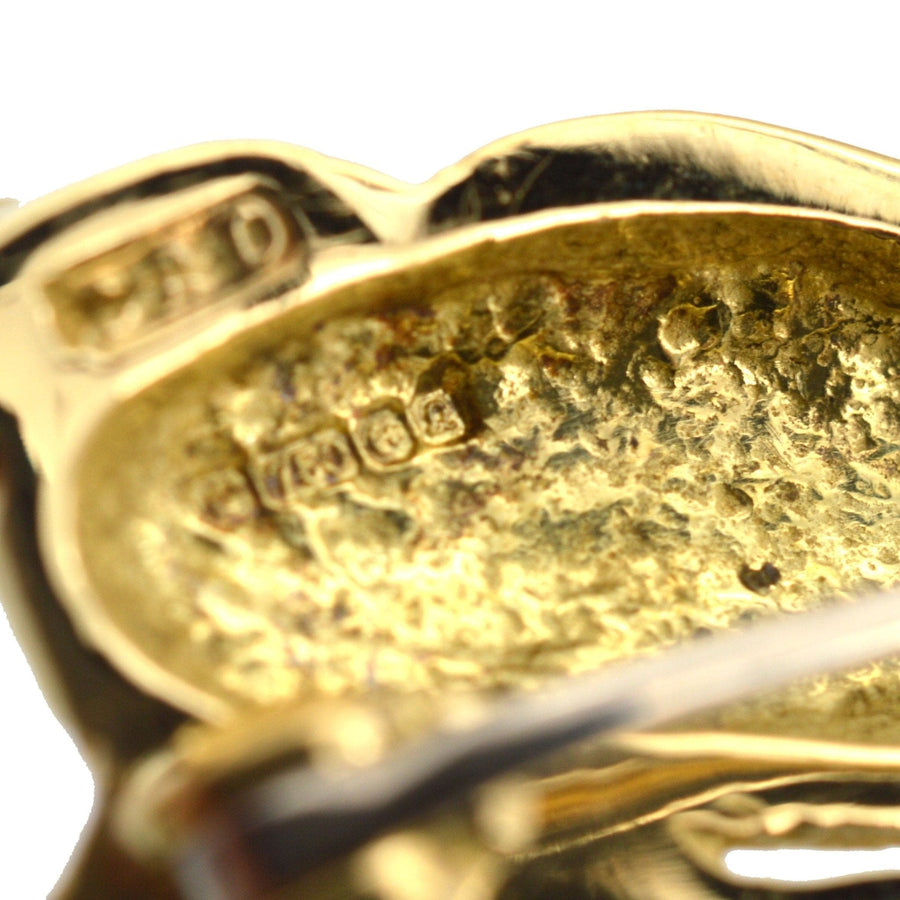Close-up of the back of a vintage 18ct gold running rabbit brooch with detailed hallmark.