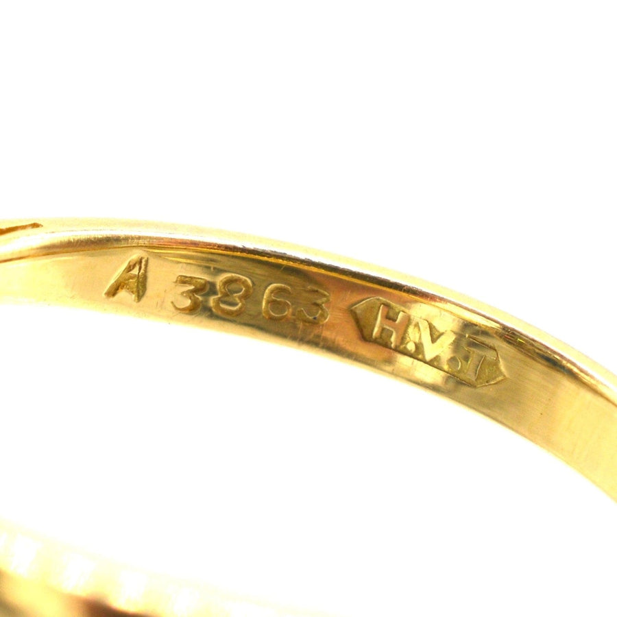 Close-up of hallmark on the inside of a vintage 18ct gold ring, showing A 3863 and H.M. markings.