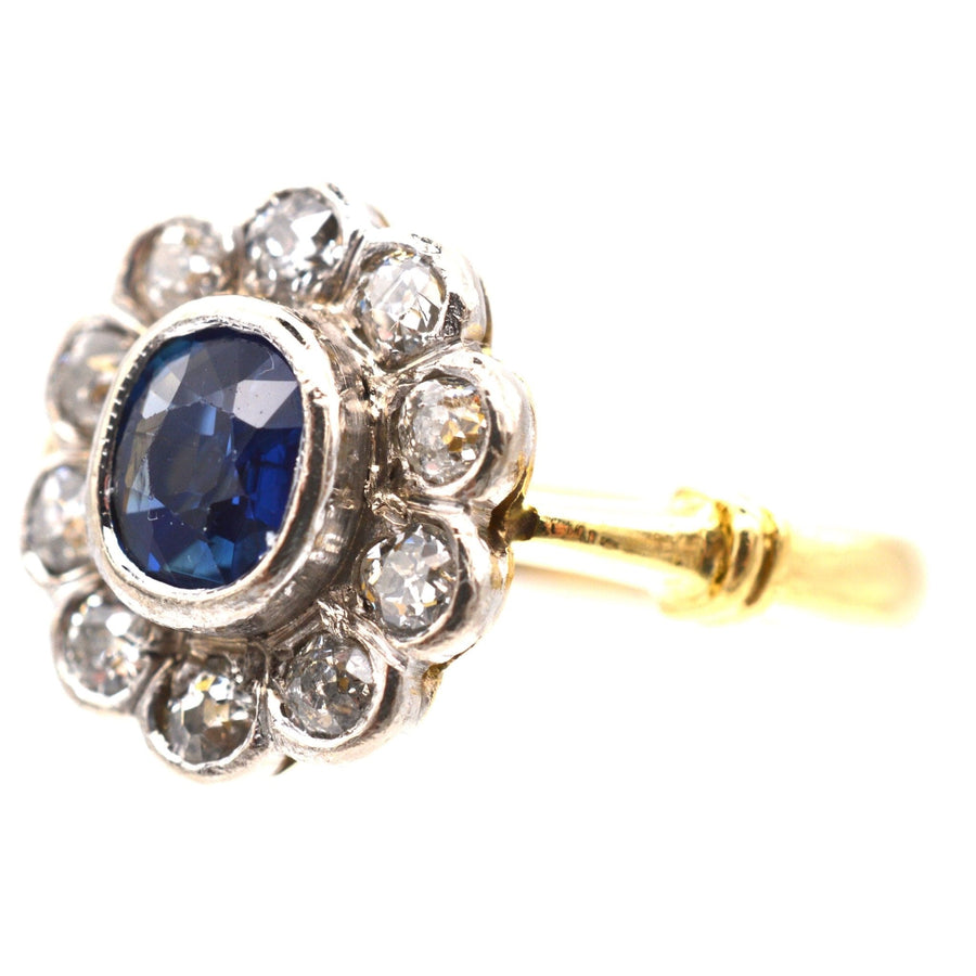 Vintage 18ct gold sapphire and diamond cluster ring, featuring a central sapphire surrounded by sparkling diamonds.