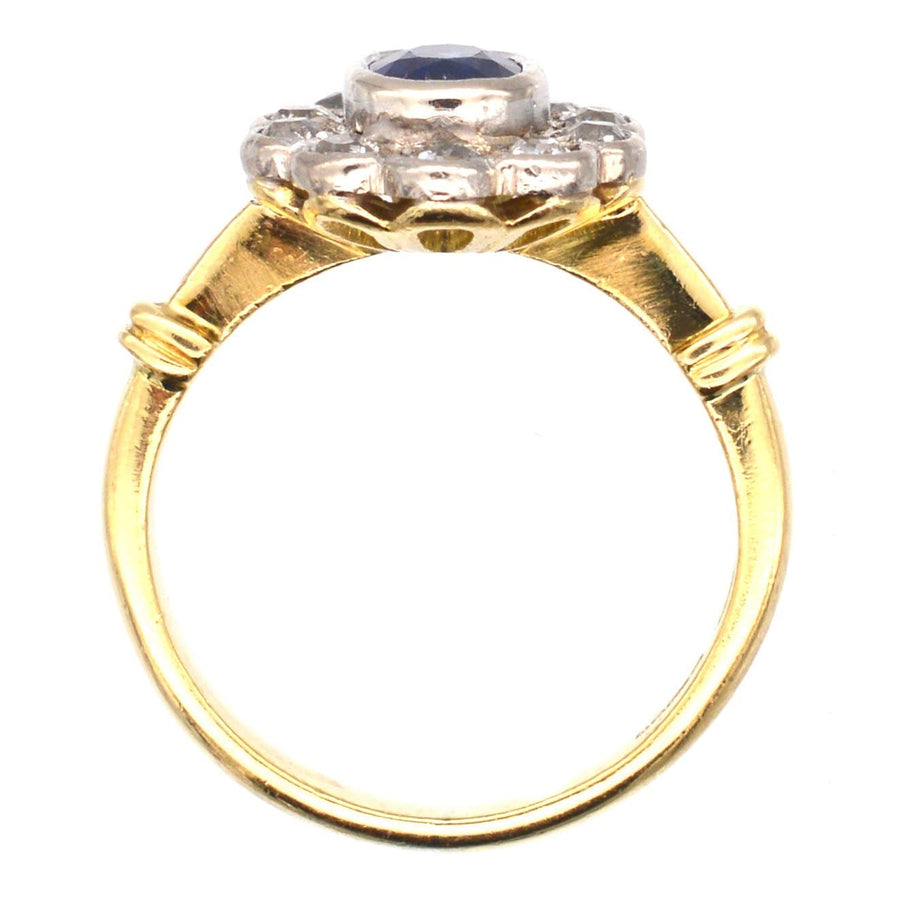 Vintage 18ct gold cluster ring featuring a sapphire center and ten sparkling diamond accents.