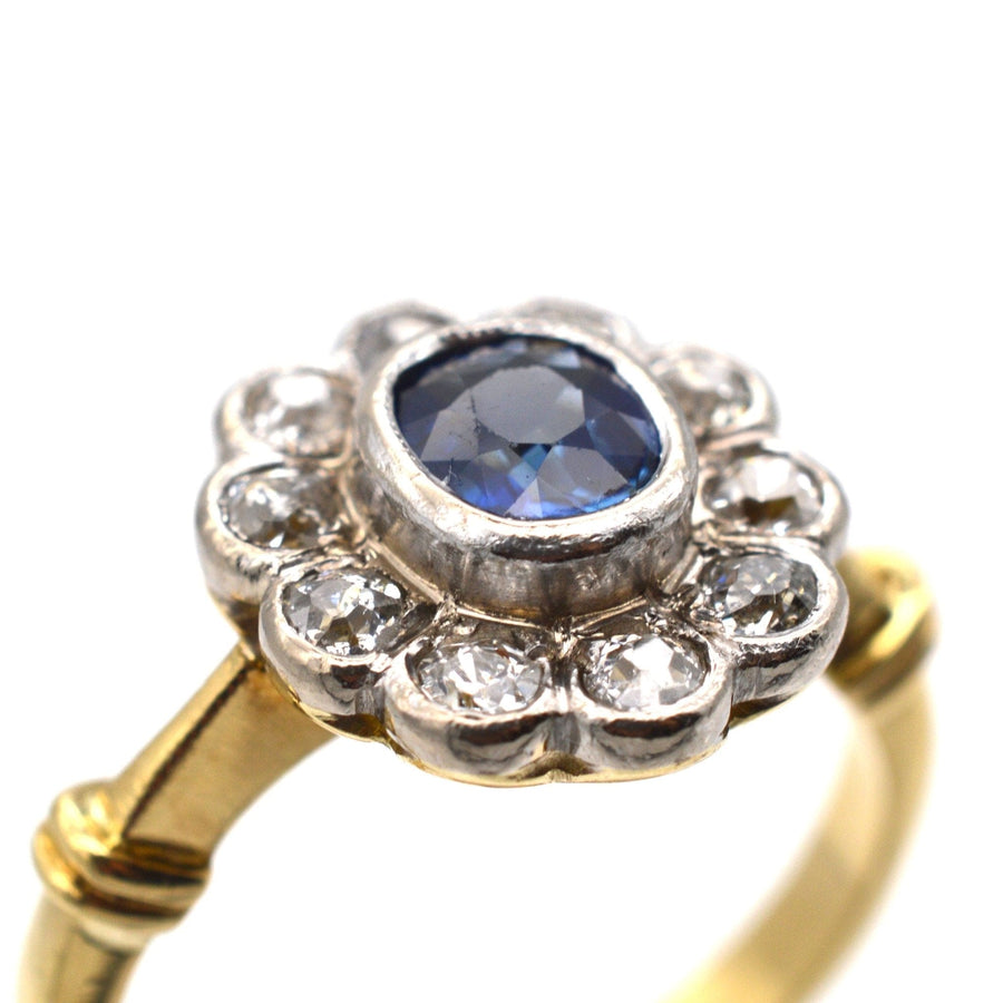 Vintage 18ct gold ring featuring a central sapphire surrounded by sparkling diamonds in a classic cluster design.