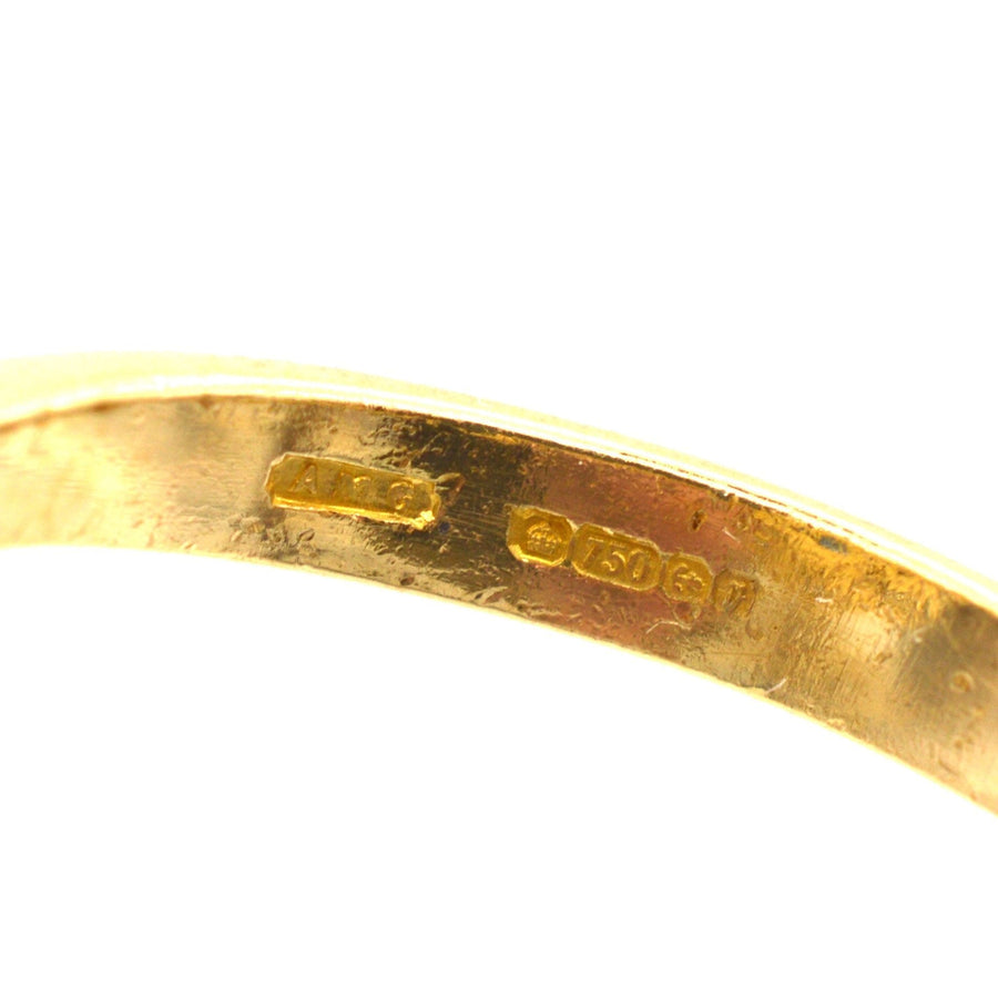 Close-up of the hallmark on 18ct gold ring, showcasing metal purity and origin details.