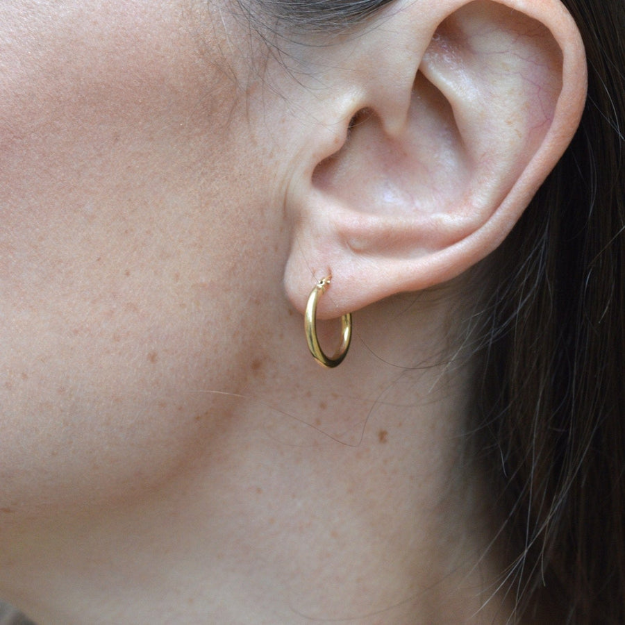 Vintage 18ct gold hoop "Huggie" earrings showcased on model's ear, perfect for any occasion.