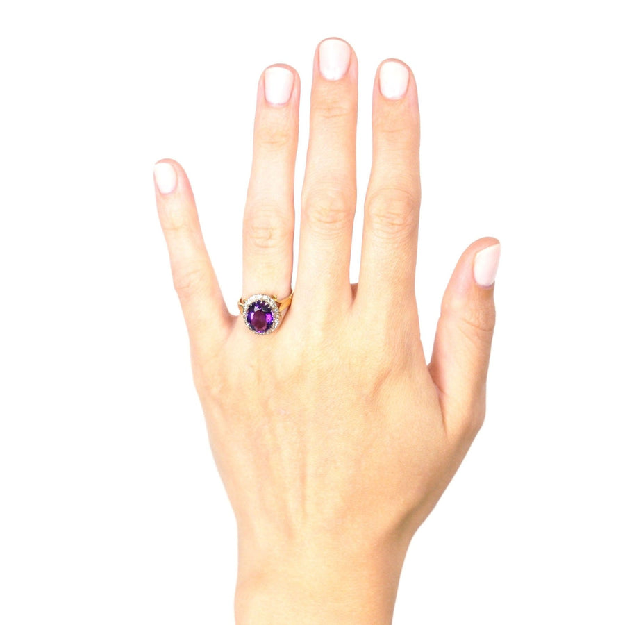 Vintage 1970s 18ct gold cluster ring featuring royal purple amethyst and diamond, showcased on a hand.