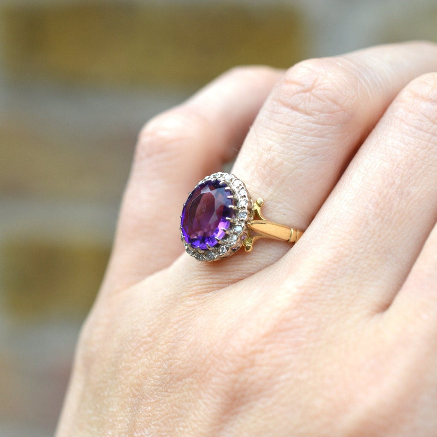Vintage 1970s 18ct gold ring featuring a royal purple amethyst and diamond cluster, elegantly worn on a hand.
