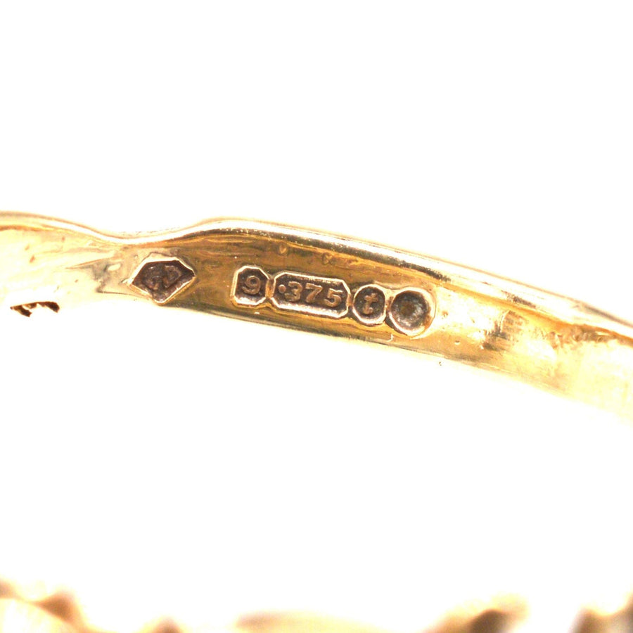 Close-up of the hallmark and purity stamp on a vintage 9ct gold acrostic ring from 1974.
