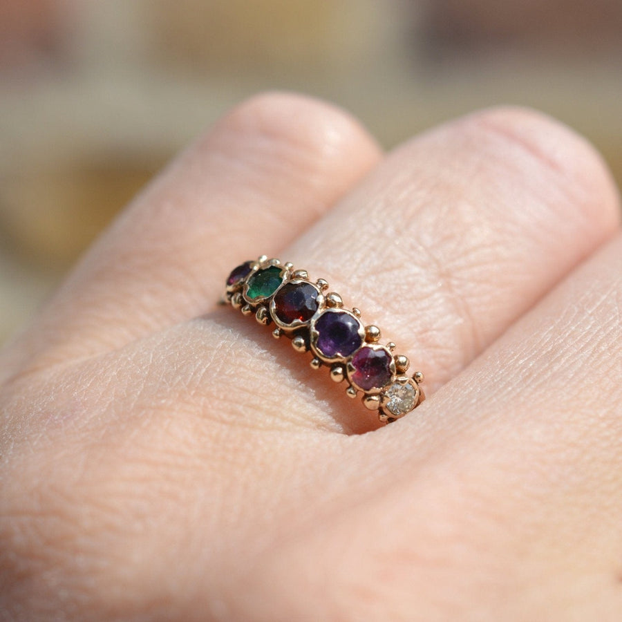Vintage 9ct gold ring featuring ruby, emerald, garnet, amethyst, and diamond spelling 'REGARD'.