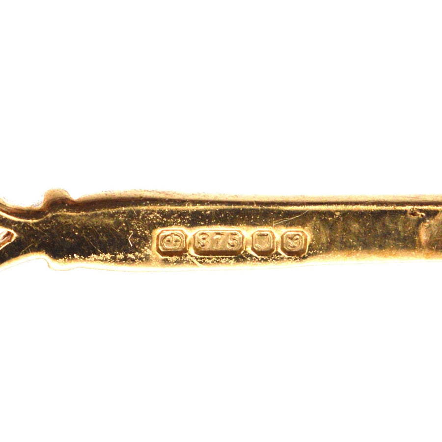 Close-up of the hallmark on a vintage 9ct gold brooch, displaying '375' stamp for gold purity.