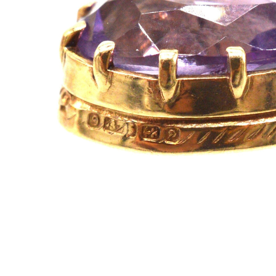 Close-up of vintage 9ct gold amethyst drop earring featuring a royal purple gemstone.