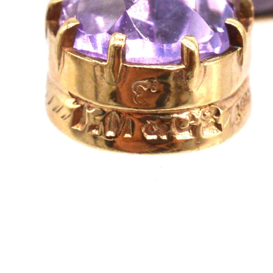 Close-up of vintage 9ct gold amethyst drop earrings, showcasing royal purple stone and intricate setting.