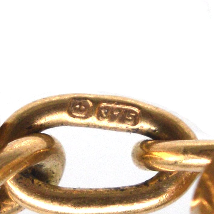 Close-up of a gold jewelry chain link, featuring the hallmark and purity stamp '375'.