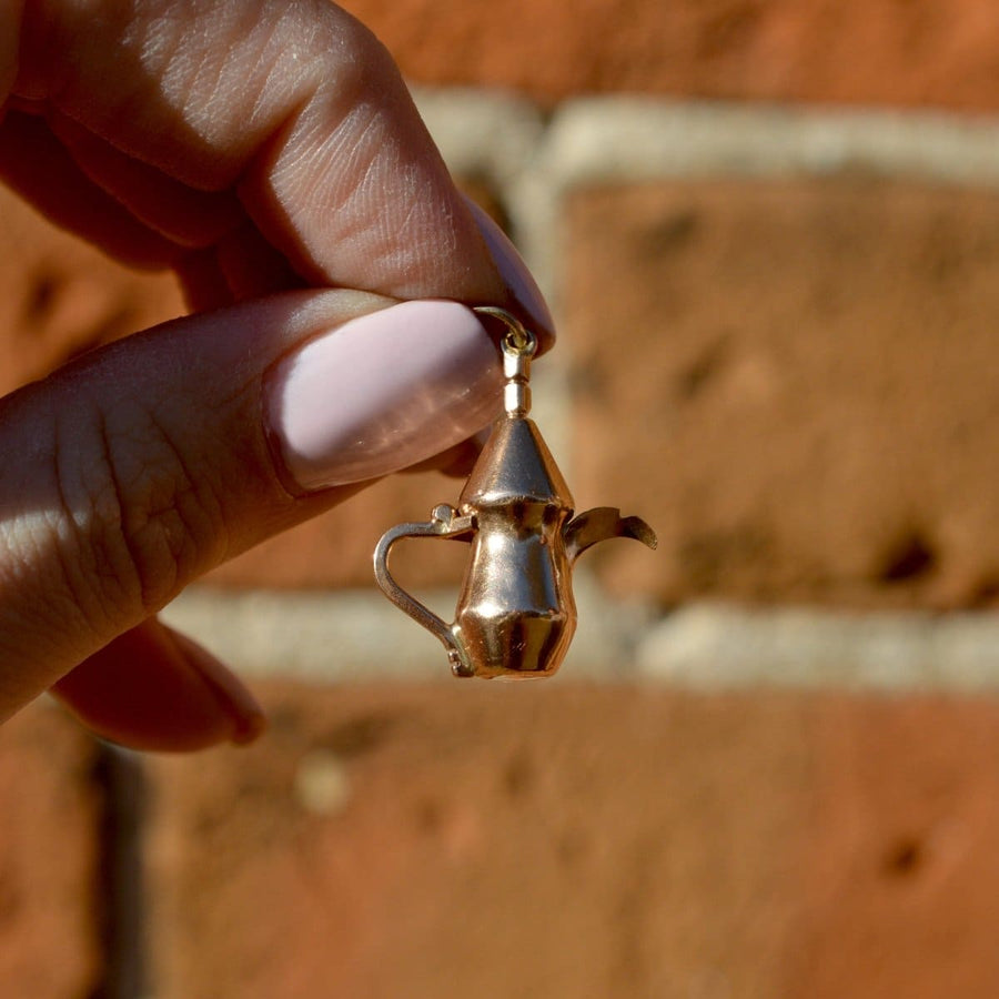 Vintage 9ct gold charm of a Middle Eastern Dallah Arabic coffee pot held by hand.