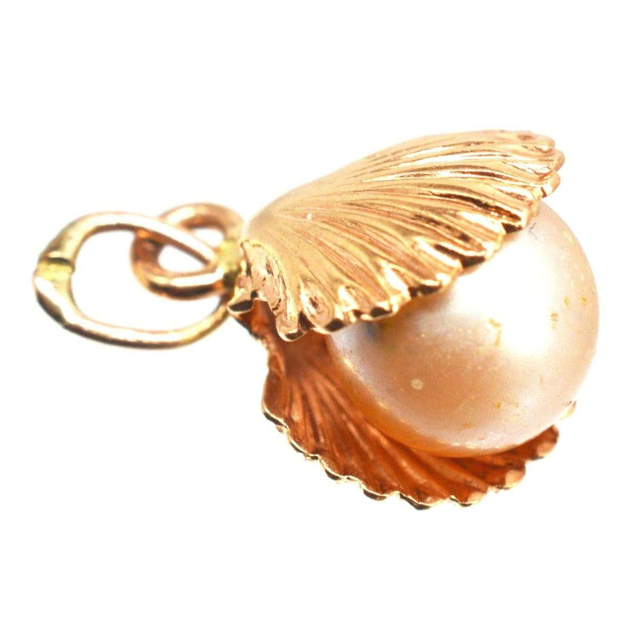 Vintage 9ct gold scallop shell charm pendant featuring an imitation pearl, symbolizing courage and protection.