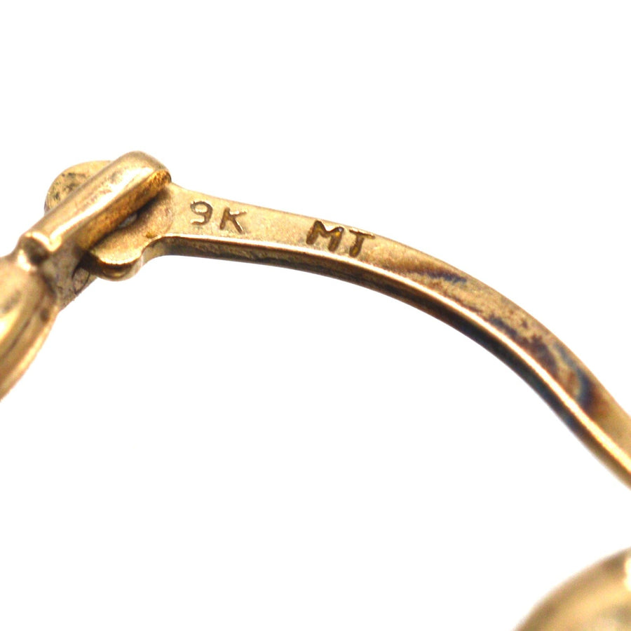 Close-up of 9ct gold hallmark on dolphin hoop earrings, showcasing fine craftsmanship and quality.