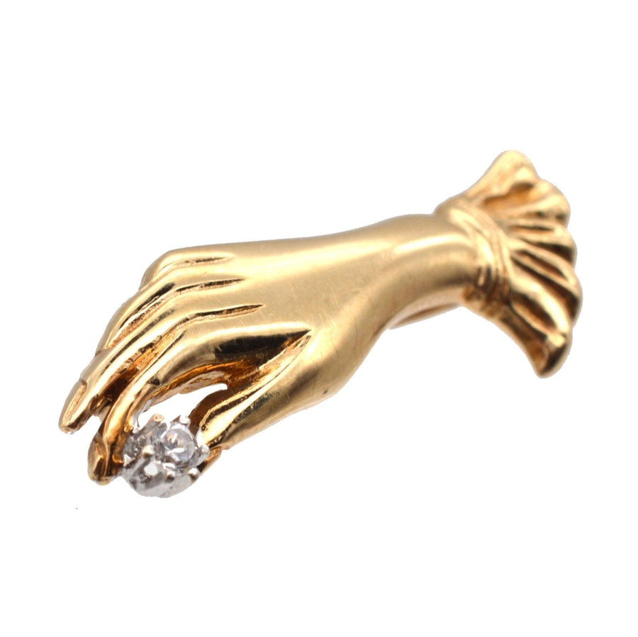 Vintage 9ct gold brooch of a gloved hand holding a diamond, showcasing timeless elegance.