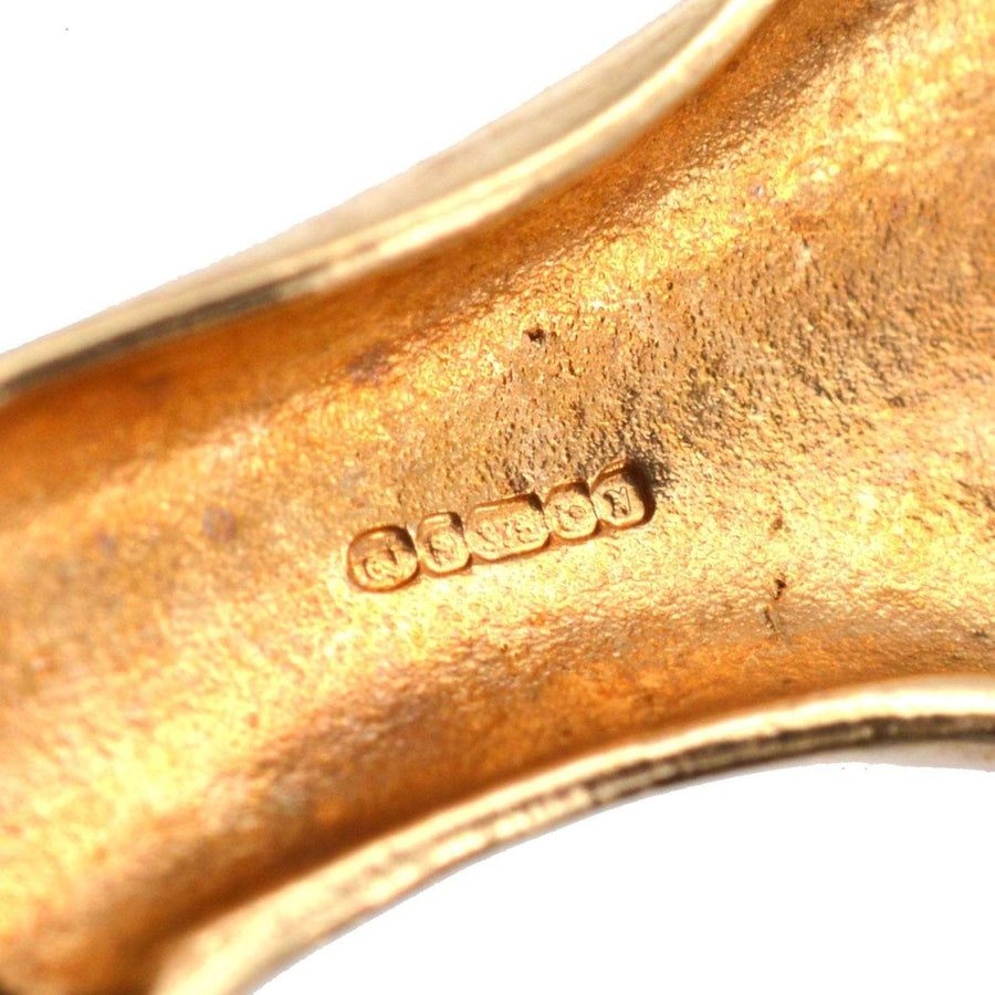 Close-up of the hallmark on a vintage 9ct gold brooch, showcasing craftsmanship and quality.