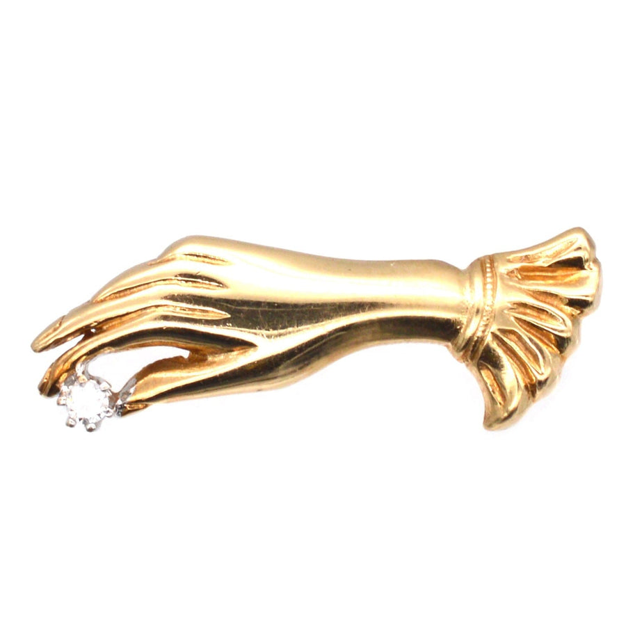 Vintage 9ct gold glove hand holding a diamond brooch, crafted in 1987 with timeless charm and elegance.