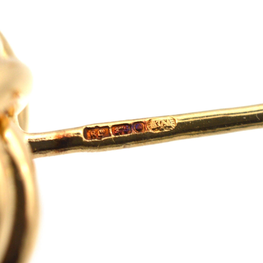 Close-up of hallmark on 9ct gold knot earrings, showcasing authenticity and quality.