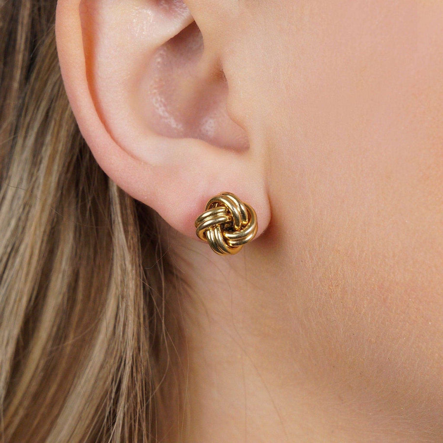 Stylish vintage 9ct gold knot earrings worn, perfect for adding formal style to any outfit.