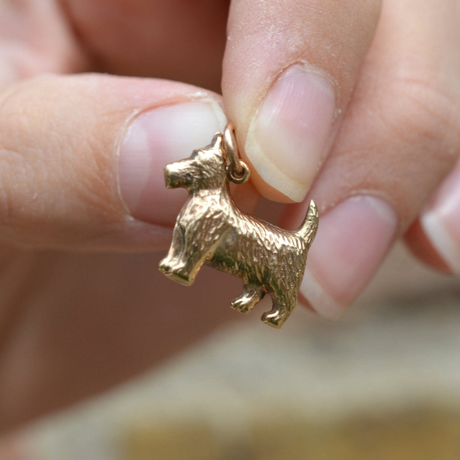 Hand holding a vintage 9ct gold Scottie dog charm pendant, perfect for bracelets or necklaces.