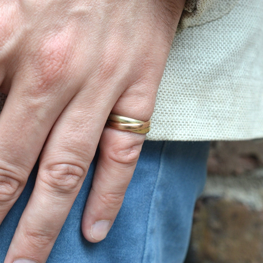 Vintage 9ct gold Trinity three-coloured band ring worn on a person's finger, showcasing a stylish design.