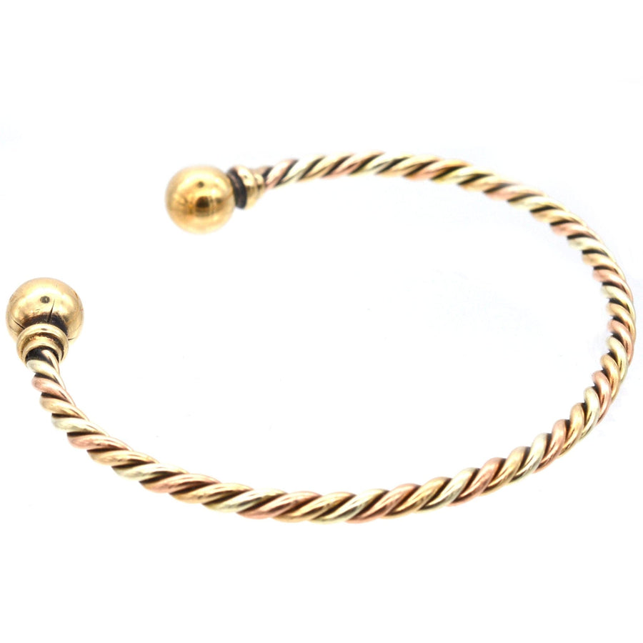 Vintage 9ct gold twisted three colour gold open bangle with gold spheres on each end.
