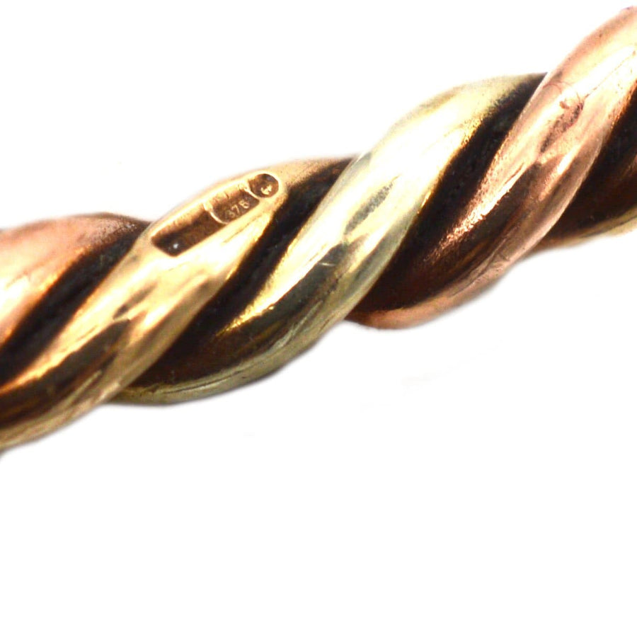 Close-up of a vintage 9ct gold twisted bangle featuring three colors of gold with a polished finish.