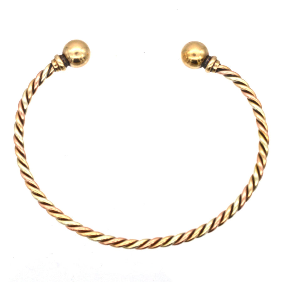 Vintage 9ct gold twisted bangle featuring three colored gold ropes and gold spheres on each end.