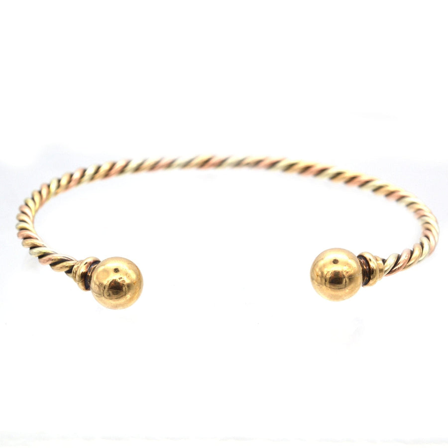 Vintage 9ct gold twisted open bangle featuring three-color gold design and gold sphere ends.