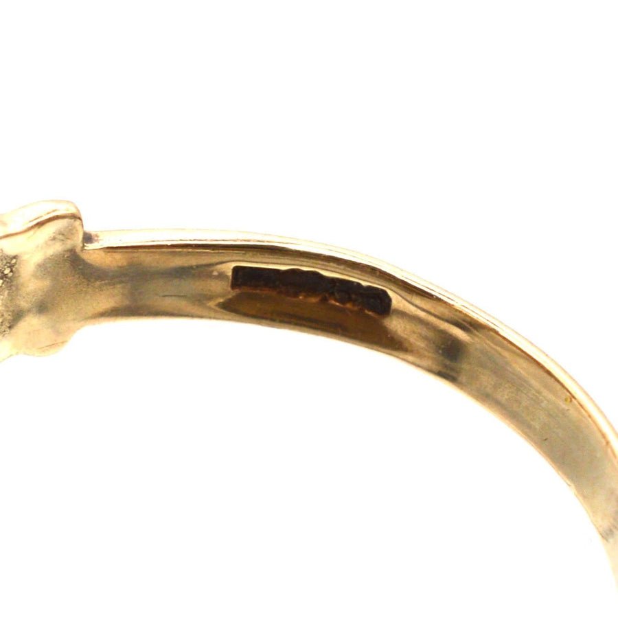 Close-up view of the inner band of a vintage 9ct Irish Claddagh ring with diamond, showcasing its hallmark.