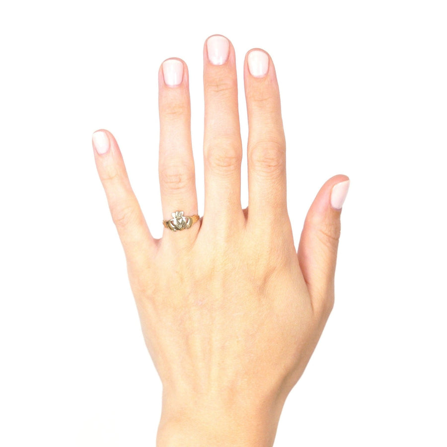 Vintage 9ct Irish Claddagh ring with diamond displayed on a woman's hand.