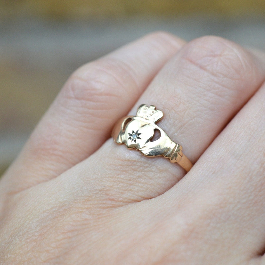 Vintage 9ct Irish Claddagh ring with diamond, symbolizing love, loyalty, and friendship, worn on a hand.