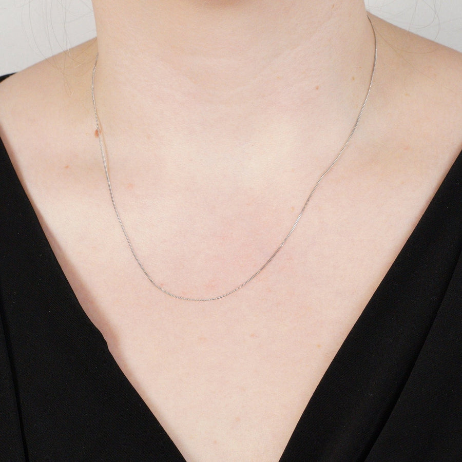 Vintage 9ct white gold flat curb chain 18 inches worn elegantly, showcasing simple everyday elegance from the 1970s.