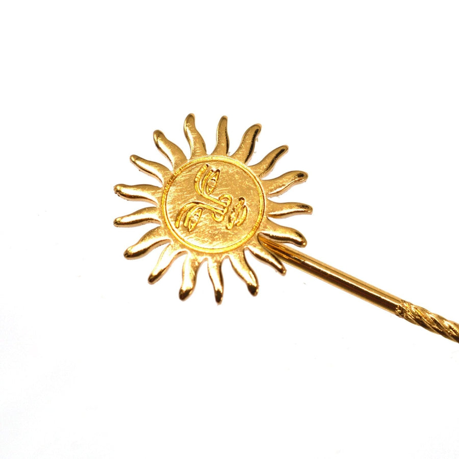 Vintage gold gilt metal sun tie pin with face design and 17 rays representing light and heat.