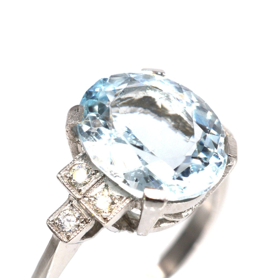 Vintage platinum aquamarine ring with diamond shoulders, featuring a 3.6 carat oval aquamarine stone.