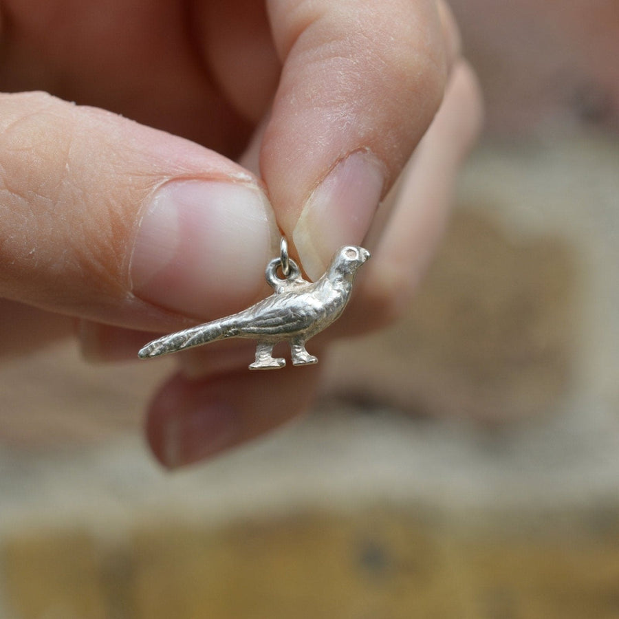 Hand holding a vintage silver pheasant bird charm, perfect for charm bracelets or necklaces.