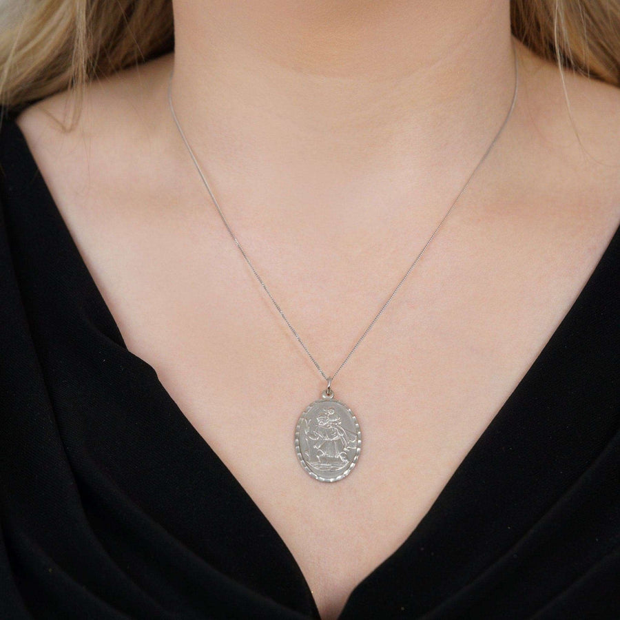 Vintage silver Saint Christopher oval pendant worn on a delicate chain, ideal for travelers seeking protection.