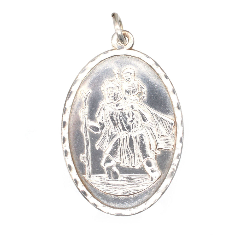 Vintage silver Saint Christopher oval pendant depicting the patron saint of travelers carrying a child.