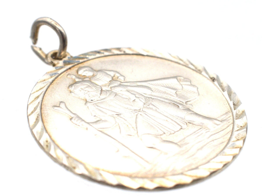 Vintage silver Saint Christopher pendant, 1970s, depicting the saint carrying a child, symbolizing protection for travelers.