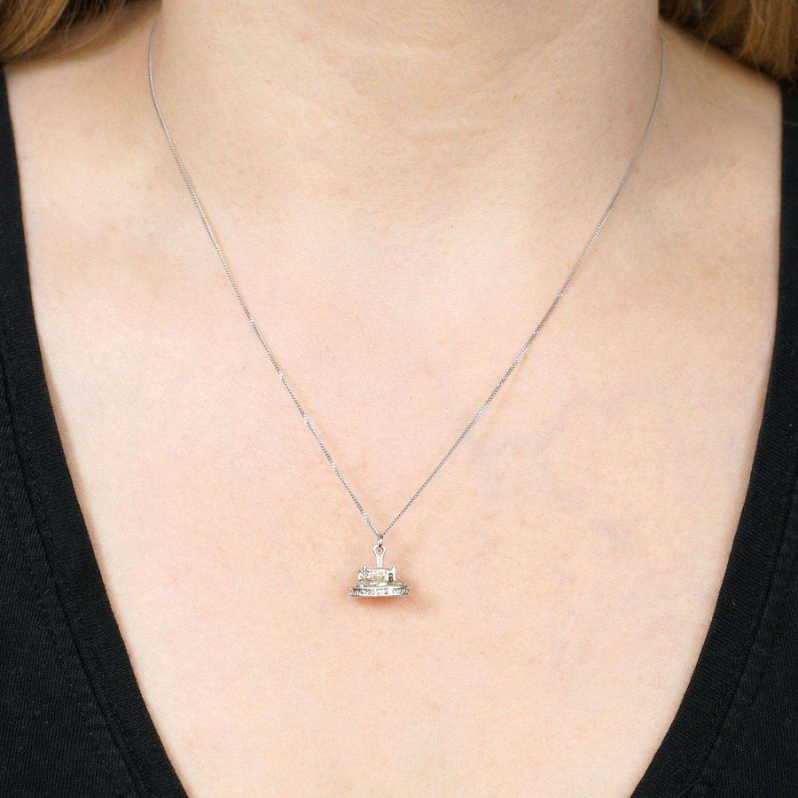 Vintage silver Saint Michael's Mount charm pendant on a delicate chain worn by a model.