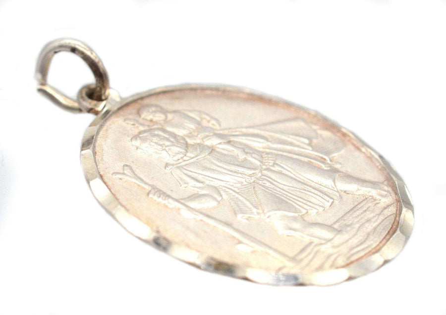 Vintage silver St Christopher pendant from the 1970s, featuring an intricate depiction of the saint with a child.